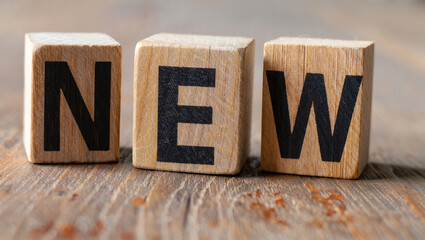Wooden Blocks Spelling New on Rustic Wooden Surface Close Up