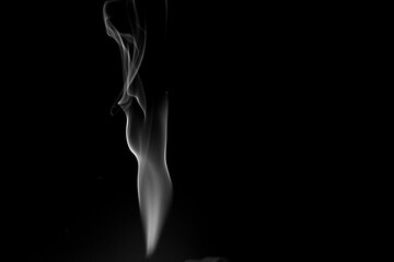 Ethereal Dance of Smoke: A wispy plume of smoke elegantly curls against a dark backdrop, creating a mesmerizing display of nature's abstract artistry.