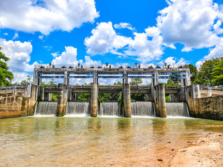 Water Flow Cascade: A grand concrete dam with multiple openings releases a powerful torrent of...
