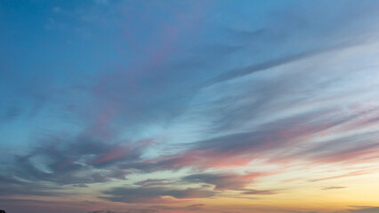 Colorful sunset skies filled with clouds over a tranquil horizon during the evening hours
