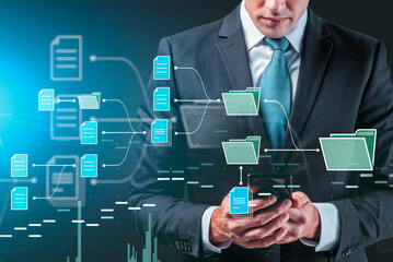 Businessman in suit holding smartphone with creative digital document and folder interface, on blue background, concept of business data management