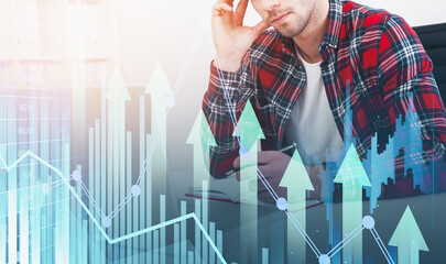 Man in casual shirt working at desk with overlay of financial graphs and arrows, on bright background, concept of business growth and market analysis