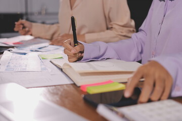 Naklejka premium Close up ux developer and ui designer brainstorming about mobile app interface wireframe design on table with customer breif and color code at modern office.Creative digital development agency.