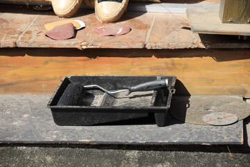 Black tray with a paint brush and a roller on it