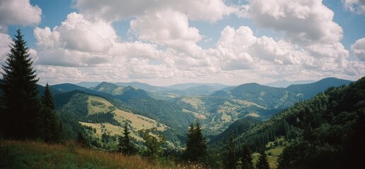 A panoramic view of rolling green hills and valleys under a partly cloudy sky on a summer day
