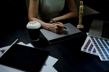 Female designer is sitting at a desk working with a colored charger