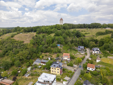Aerial view of the dominating Spitzhaus tower standing tall amidst the verdant hills and quaint houses, Radebeul, Saxony, Germany.