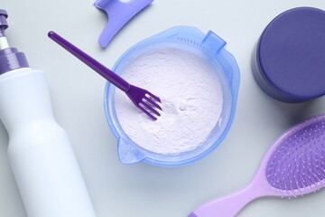 Hair care product for blonde hair and hairdresser's tools on white background, flat lay