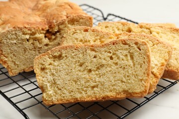 Freshly baked cut cornbread on white table, closeup
