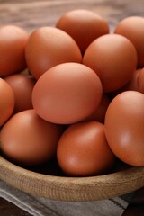 Raw chicken eggs in bowl on table, closeup
