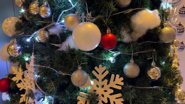 4k footage close up of lighted Christmas tree ornaments and decorations. Mistletoe, baubles, and bell with Interactive sparkling christmas twinkle lights or icicle lights.