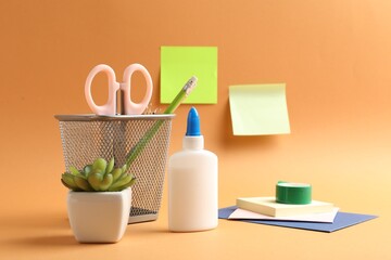 Glue and other stationery on pale orange background