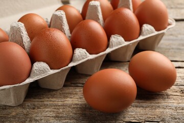 Raw chicken eggs on wooden table, closeup