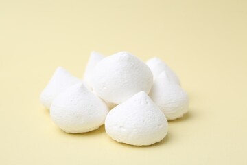 Yummy meringue cookies on beige background, closeup