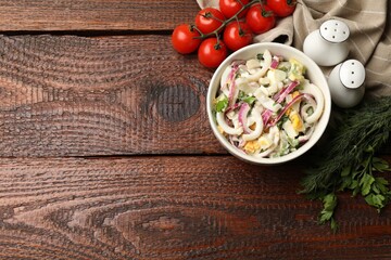 Tasty salad with squid rings, onion and eggs served on wooden table, flat lay. Space for text