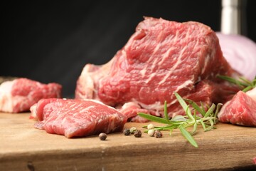 Pieces of raw beef meat and spices on table, closeup