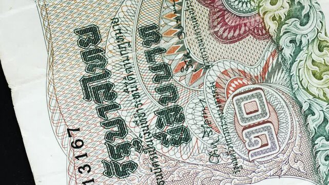 Thailand 20 Baht banknote obverse with royal portrait and Thai script detail rotating on black background
