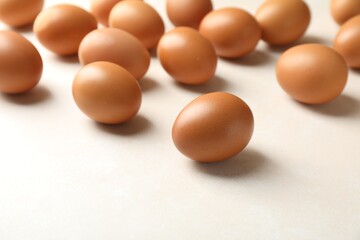 Many raw chicken eggs on light table, closeup