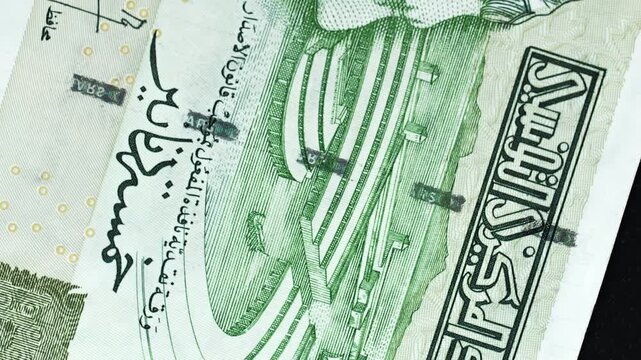 Tunisia 5 Dinar banknote obverse with Arabic script and amphitheatre engraving rotating on black background