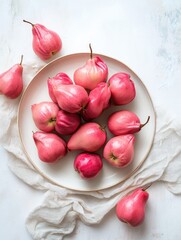 Overhead shot of ripe pink pears on a white plate
