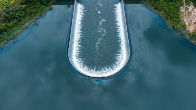 Aerial view of water cascading over a curved weir, creating a mesmerizing display of textures and tones, Along Zuma Barracks, Suleja, Niger, Nigeria.