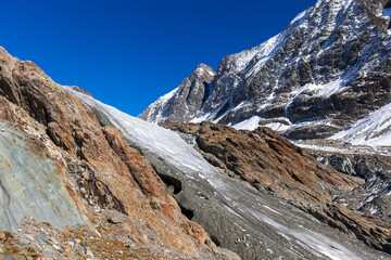 Glacier tongue flowing over rugged mountains. View of the anun and langgletscher in Loetschental valley in Valais, Switzerland
