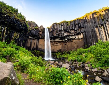 Waterfall cascading down basalt cliffs