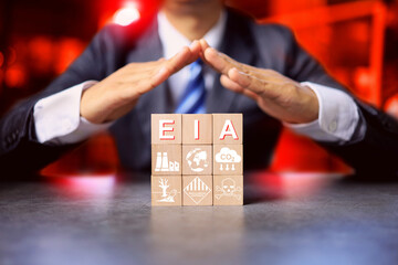Environment impact assessment EIA concept with a man arrange wooden block with hazard icon that could be effect to surrounding project such as waste water, air pollution, chemical toxic and noise