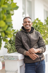 Fototapeta premium Handsome man in hoodie enjoys autumn warmth in vibrant Miami gardens