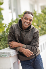 Fototapeta premium Handsome man in a hoodie smiles casually in Miami during autumn days