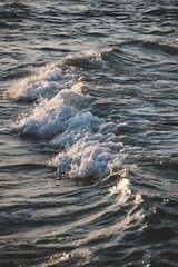 Close up view of ocean waves breaking with sunlight reflecting on water