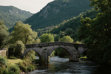 Fototapeta premium Classic stone bridge crossing a calm river, surrounded by lush greenery