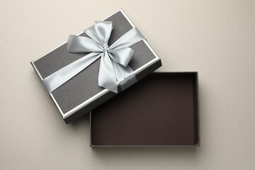 Open gift box with beautiful lid on light grey background, top view