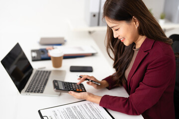 Focused female real estate agent reading and Reviewing contract document for real estate property purchase.