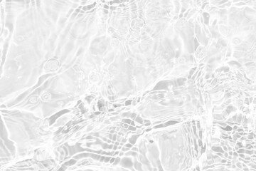 White water with ripples on the surface. Defocus blurred transparent white colored clear calm water surface texture with splashes and bubbles. Water waves with shining pattern texture background.