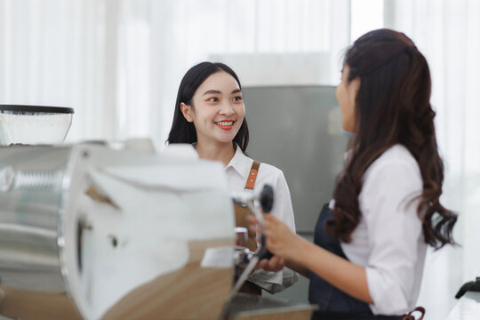 Baristas smiling while preparing coffee