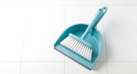Plastic dustpan and brush placed diagonally on clean ceramic tiles. Household cleaning equipment for daily chores. Top view with copy space