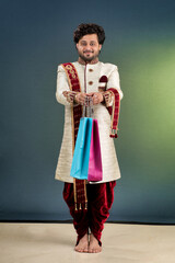 Indian traditional Young handsome man holding and posing with shopping bags