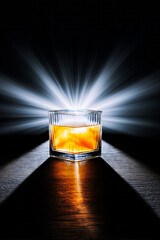 Whiskey glass glowing with striking light rays