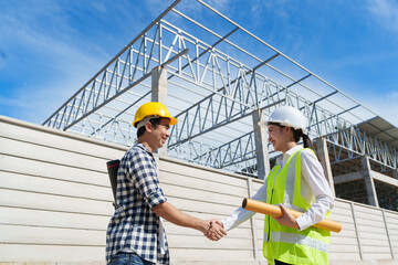 Construction workers shaking hands on building site