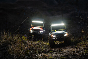Two radio-controlled off-road vehicles driving at night in nature © Zoran Jesic