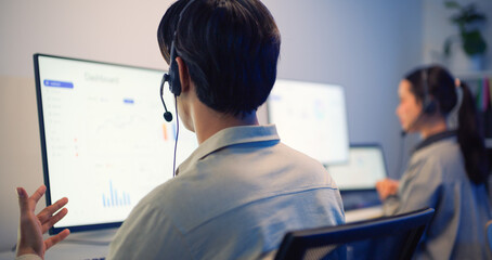 Obraz premium Customer service representatives wearing headsets working on computers in modern office, providing assistance and communication support.