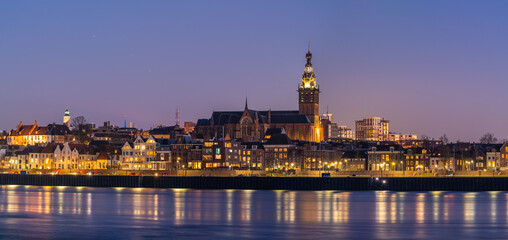 City skyline glows at twilight with water reflections