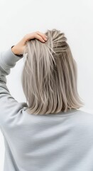 Womans back with hand on head showing hair style against white background