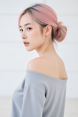 Young asian woman with pink hair posing in modern studio setting