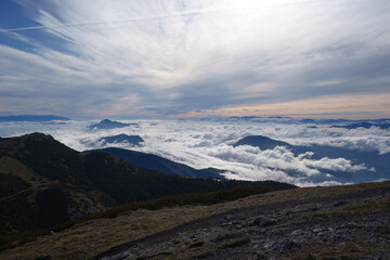 Obraz premium Misty cloud inversion over Malá Fatra mountains, Slovakia, with dramatic sky, layered peaks, and moody atmosphere. Majestic nature and scenic beauty above the clouds.
