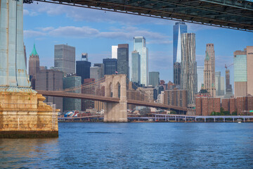 Fototapeta premium Majestic Brooklyn Bridge graces the NYC skyline. Soaring steel arches frame the cityscape, bathed in warm sunlight. Iconic landmark for travel and architecture projects. wallpaper, 4k 