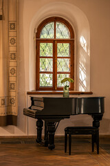 Grand piano under arched window with traditional decor