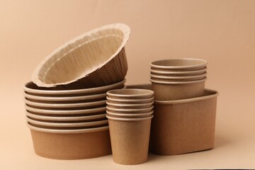 Set of disposable tableware on dark beige background, closeup