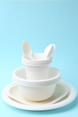 Set of disposable plastic tableware on light blue background